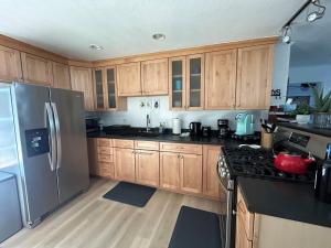 a kitchen with wooden cabinets and a stainless steel refrigerator at COH0957 - Bella Ari home in South Lake Tahoe