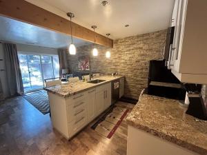 - une cuisine avec un évier et un mur en briques dans l'établissement HCC0410 - Heavenly Hideaway condo, à South Lake Tahoe