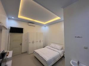 a small bedroom with a bed and a ceiling at Backyard Guest House in Banjar