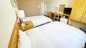Rúm í herbergi á Hotel Route-Inn Yokkaichi