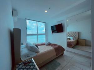 una camera da letto con un letto e una grande finestra di Seafront Apartment Infinity Pool Rooftop a Città di Panama