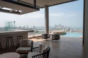 una habitación con sillas y un bar con vistas a la ciudad en Murano Centro1 26floor,rooftop,infinity pool & views by IMZ, en Cartagena de Indias