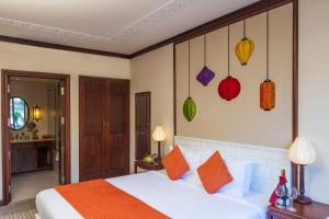 Postel nebo postele na pokoji v ubytování Cozy Original Hoi An Hotel