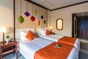 Postel nebo postele na pokoji v ubytování Cozy Original Hoi An Hotel