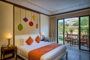 Postel nebo postele na pokoji v ubytování Cozy Original Hoi An Hotel
