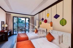 Postel nebo postele na pokoji v ubytování Cozy Original Hoi An Hotel