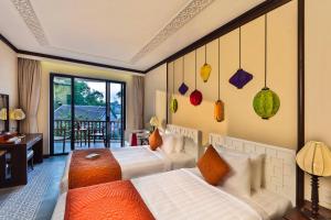 Postel nebo postele na pokoji v ubytování Cozy Original Hoi An Hotel