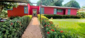 a red house with a pathway in front of it at Casa Campestre in Yopal