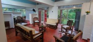 a living room with wooden chairs and windows at Casa Campestre in Yopal