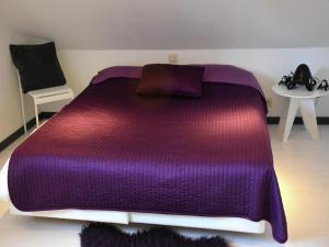ein violettes Bett in einem Zimmer mit einem Tisch in der Unterkunft Lake-view apartment with sauna, hot tub in Grand Coo