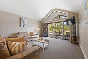 a living room with a couch and a table at Sea Foam Villas in Port Campbell