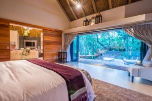a bedroom with a bed and a large window at AM Lodge - Hoedspruit in Hoedspruit +97 photos