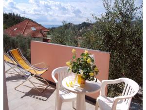 a table with a vase of flowers on a balcony at Studio für 4 Personen in Imperia in Imperia