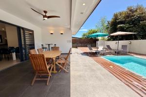 PiraeVilla Moea private pool confort & serenity in Pirae - AC- Wifi - 3 bdr的有游泳池、桌椅的房子
