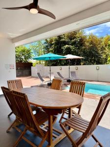 PiraeVilla Moea private pool confort & serenity in Pirae - AC- Wifi - 3 bdr的带游泳池的露台上有一张木桌和几把椅子 更多26张照片