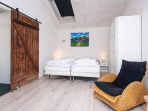 two beds in a room with a door and two chairs at Luxury Retreat in Blavand - By Traum Ferienwohnungen in Blåvand