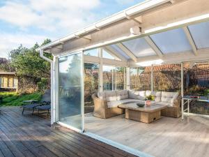 a conservatory with a couch and a table on a deck at Luxury Retreat in Blavand - By Traum Ferienwohnungen in Blåvand
