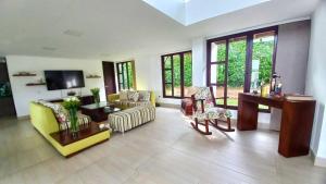 a living room with a yellow couch and chairs at Santa Isabel Campestre in Armenia