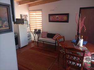 a living room with a table and a chair at Dpto pelluhue mar in Curanipe
