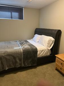a bedroom with a bed with a black headboard at Unique home services in Bélanger