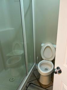 a bathroom with a toilet and a glass shower at Unique home services in Bélanger
