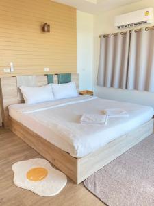 a bedroom with a large bed with white sheets at The moon camp khanom in Ban Plau