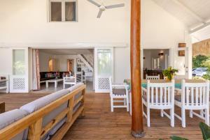 - une terrasse couverte avec des chaises blanches et une table dans l'établissement Caribbean Beach Villa Playa Bonita Las Terrenas, à Las Terrenas