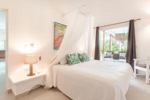 une chambre blanche avec un lit et une fenêtre dans l'établissement Caribbean Beach Villa Playa Bonita Las Terrenas, à Las Terrenas 61 autres photos