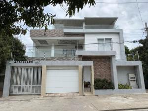 a large white house with a garage at Apartamentos Kars in Ríohacha