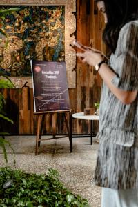 a woman standing in front of a sign at ARTOTEL Haniman Ubud in Ubud