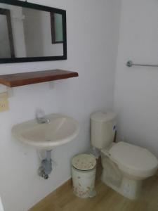 a bathroom with a sink and a toilet and a mirror at ALDEA VACACIONAL LA FLORIDA in Santa Fe de Antioquia