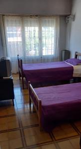 two beds in a room with windows at Ensueñoneco in Necochea