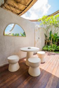 a table and two stools on a wooden deck at M&M Dream Villa - 2 BR Villa in Kerobokan in Kerobokan