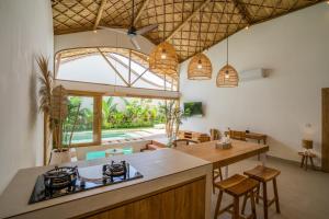 an open kitchen and dining room with pendant lights at M&M Dream Villa - 2 BR Villa in Kerobokan in Kerobokan