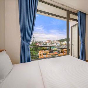 a bedroom with a bed and a window with a view at Ami Villa Dalat in Da Lat