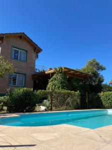 a swimming pool in front of a house at Viento Sur in Villa General Belgrano