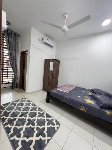 a bedroom with a bed and a rug on the floor at TDH Homestay #5 in Kangar