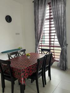 a dining room table and chairs with a table and a window at TDH Homestay #5 in Kangar