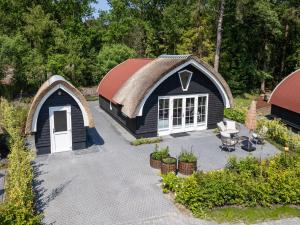an overhead view of a black house with a thatched roof at Holiday Home in Forest near Assen in Baars