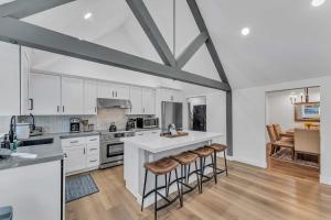 a kitchen with white cabinets and bar stools at Luxurious 7BR Walk 2 Beach and Bus Stop in Carnelian Bay +32 photos
