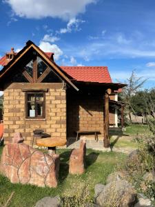 a log cabin with a bench and a table at La Casa del Abuelito in San Miguel Regla