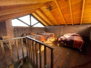 a attic room with four beds and a window at La Casa del Abuelito in San Miguel Regla