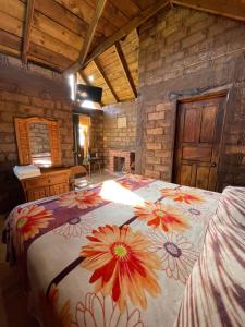 a bedroom with a large bed with a flower blanket at La Casa del Abuelito in San Miguel Regla