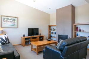 a living room with a couch and a television at Spacious Home with a Lake View in Taupo