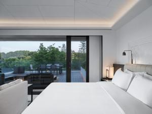 溧阳FU VALLEY Hotel的卧室里有一张白色的大床和一个阳台 更多37张照片