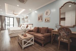 a living room with a bed and a couch and a table at Samson Soleil Hotel in Sầm Sơn