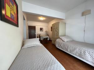 ein Zimmer mit zwei Betten und einem Tisch darin in der Unterkunft Lo de Lau, Mar del Plata in Mar del Plata
