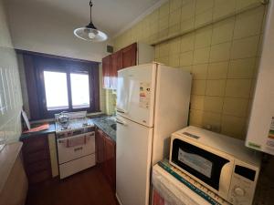 eine Küche mit einem weißen Kühlschrank und einer Mikrowelle in der Unterkunft Lo de Lau, Mar del Plata in Mar del Plata