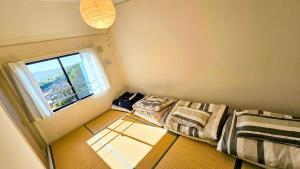 a small room with a bed and a window at goodRAC stay kyoto Kameoka in Yagi
