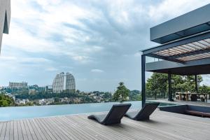 two chairs sitting on the edge of a pool on a building at Amulya Luxury Villa, Dago - 4BR Heated Infinity Pool in Bandung